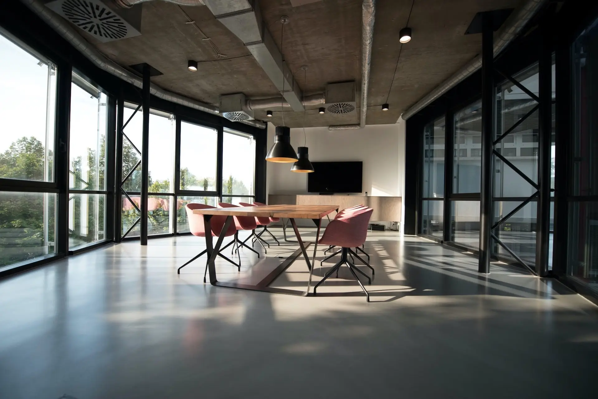 Salle de réunion lumineuse d’un organisme de formation, baies vitrées et table de travail